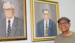 Maldonado frente a los retratos del Dr. José Rosario y Frank Morales.